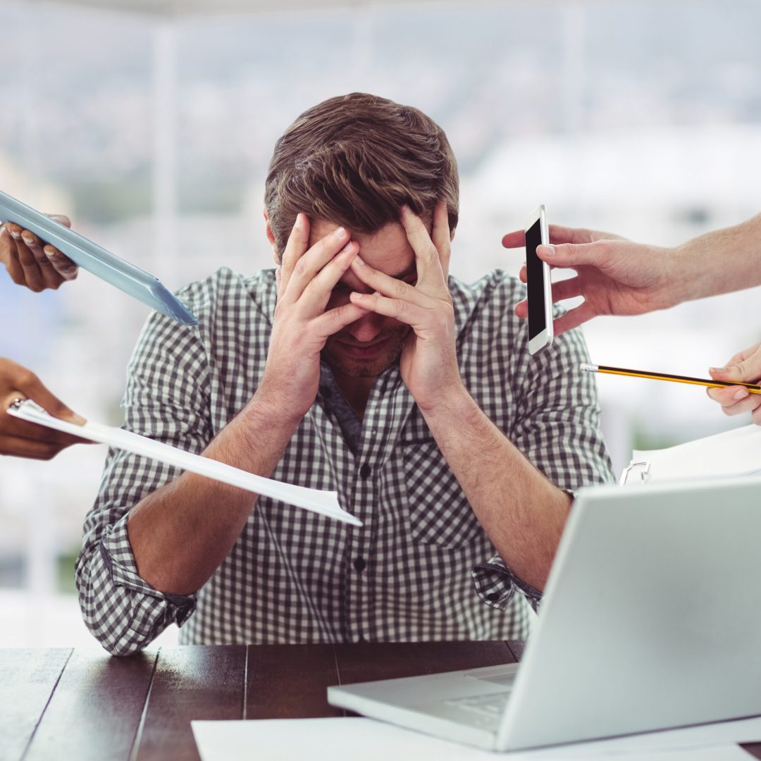 Stressed man frustrated with electronic devices in office